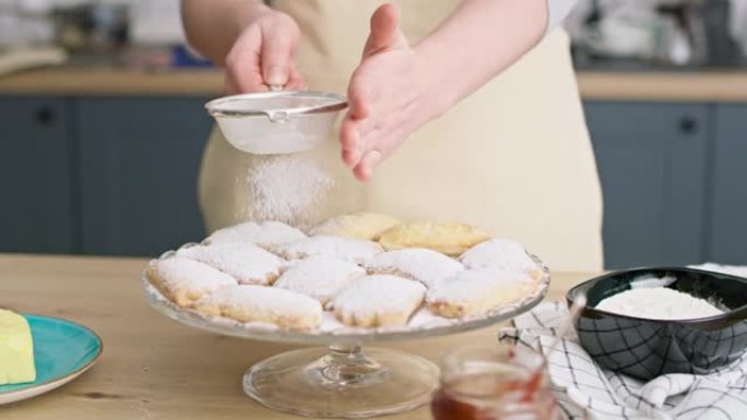 女人用糖粉撒和装饰饼干的视频。用8k的红氦相机拍摄。