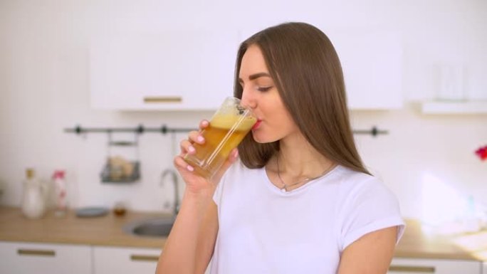 苹果汁-女人在厨房里榨汁苹果并在家里新鲜饮用。果汁机和健康饮食快乐的女人制作果汁。新鲜苹果汁