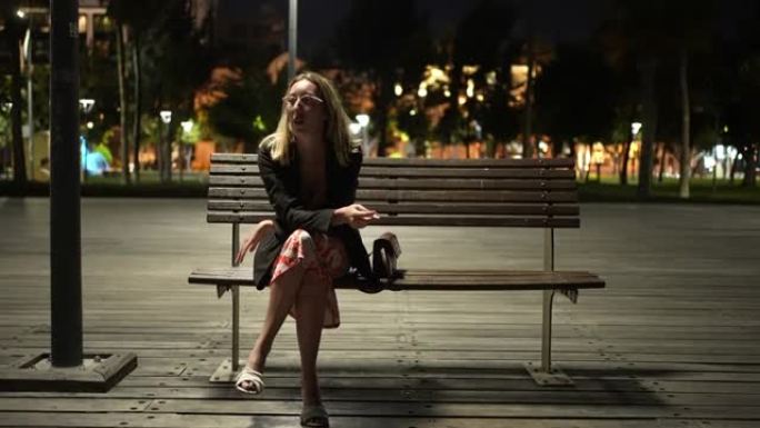 疲倦而沉思的女人，经过漫长的一天，晚上在码头上抽烟放松