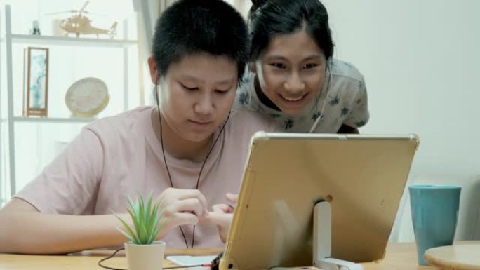 在新型冠状病毒肺炎，检疫和社交距离的生活方式概念中，亚洲女孩在家里的餐桌上通过数字平板电脑学习在线课
