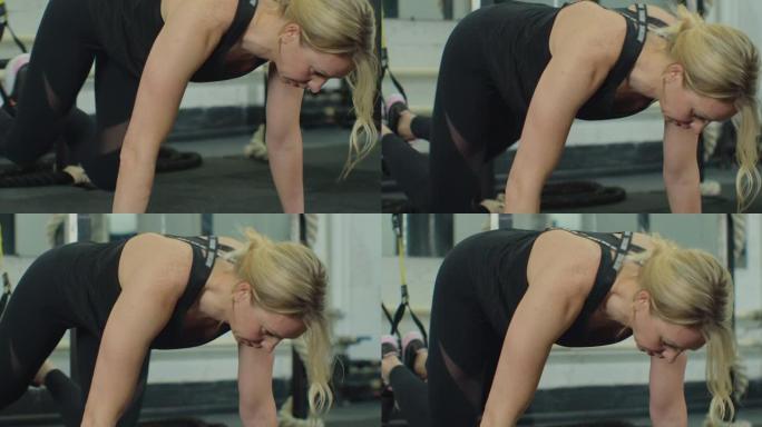 使用trx运动场训练女运动员。年轻女子锻炼悬挂系统健康的生活方式在健身房伸展。