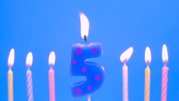 在蓝色背景上点燃5号蜡烛作为生日