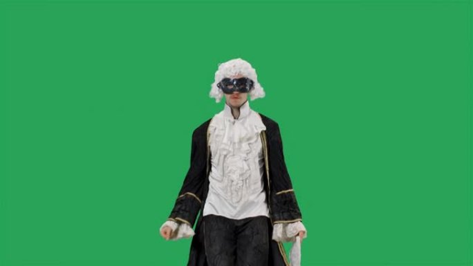穿着黑色历史复古西装、白色假发和面具的朝臣绅士肖像，手里拿着扇子欢快地跳舞。年轻人在工作室摆姿势，绿