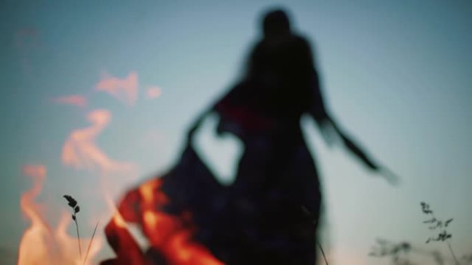 神秘女人在火火焰后跳舞的模糊轮廓，火花，缓慢的动作