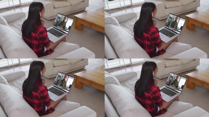 非裔美国妇女坐在家里的沙发上在笔记本电脑上进行视频通话
