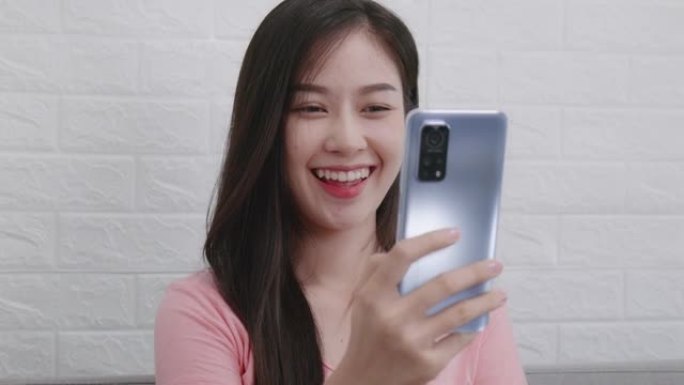 博客作者或有影响力的亚洲女性在家打视频电话，女孩使用技术手机记录社交媒体上的vlog上传