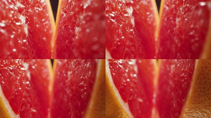 4k微距视频，将水和滴落的水滴切成两半，新鲜美味的葡萄柚。有机食品和健康营养的完美抽象镜头。