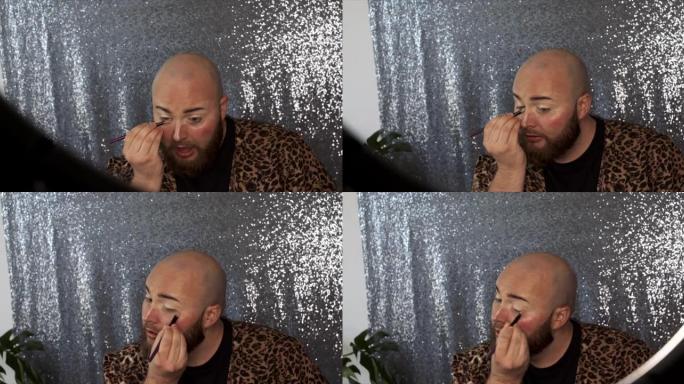 一名男性化妆师在眼睛周围混合遮瑕膏的4k视频片段