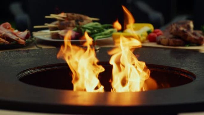 烤架变热，在外面烹饪食物。烧烤炉中燃烧的火焰