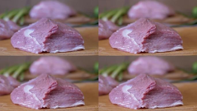 一块新鲜的生猪肉扔到切菜板上。排骨，牛排。4K