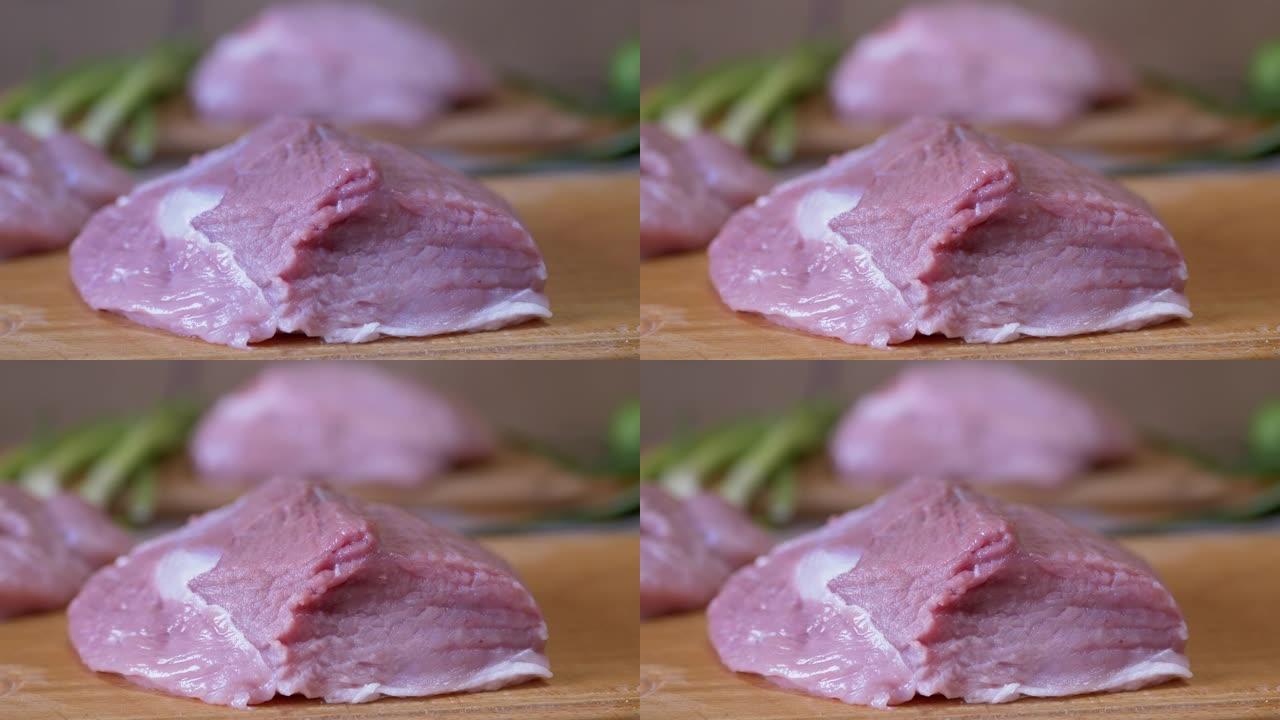 一块新鲜的生猪肉扔到切菜板上。排骨，牛排。4K
