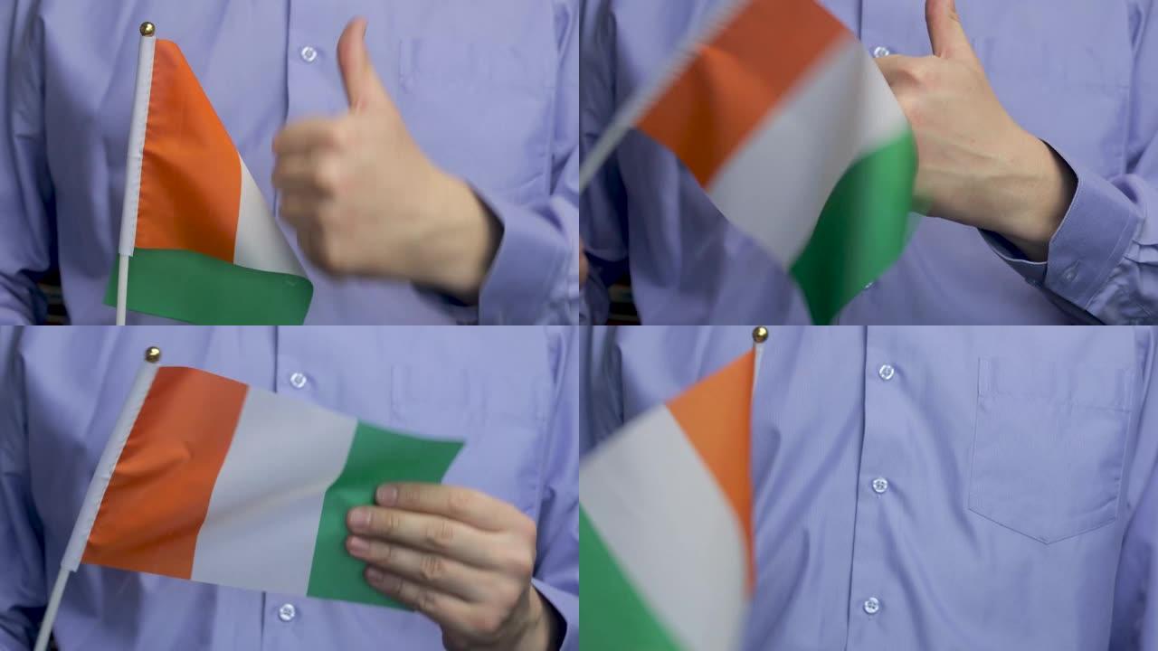 一名男子举着爱尔兰国旗挥舞着，竖起大拇指。