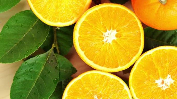 橙色水果与切片特写，顶视图旋转水果，甜橙色水果与绿色叶子在花园里。