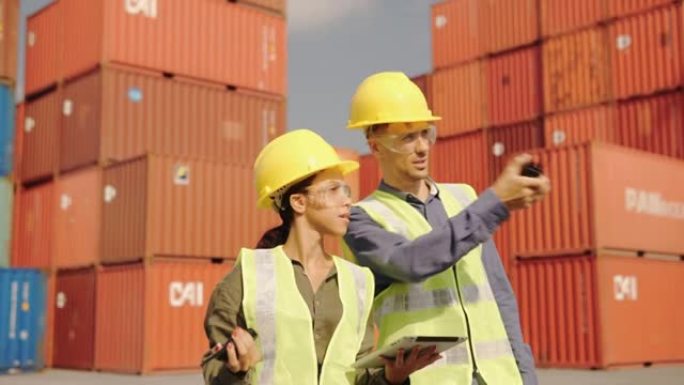 物流工程师一起工作集装箱码头员工工作和交谈检查货物货运船的集装箱装载监控系统，以供进出口。