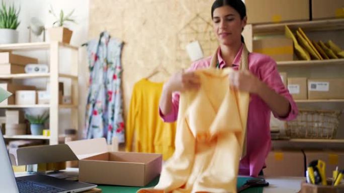 年轻的女企业家打包衣服交付给客户