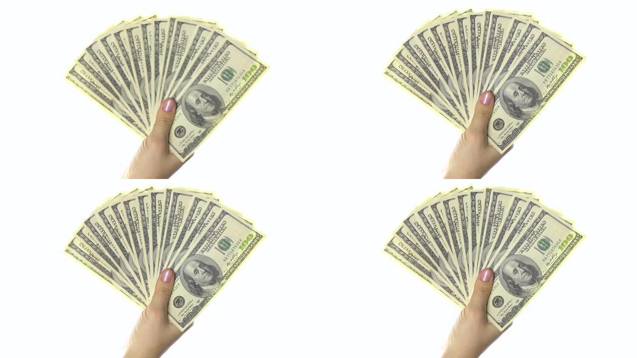 女人的手像扇子一样拿着100美元的钞票。白色背景。