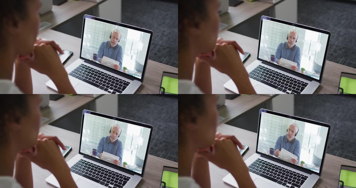 非裔美国妇女的中间部分在办公室的笔记本电脑上与男同事进行视频通话