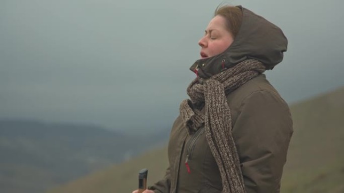 中年妇女站在迷雾山脉的背景下