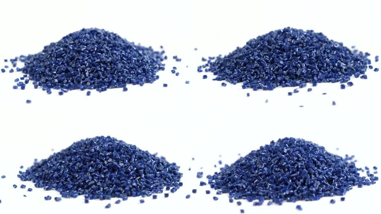 由聚丙烯制成的次级颗粒，深蓝色塑料颗粒在孤立的背景上崩溃。工业用颗粒塑料原料。聚合物树脂。生塑料回收