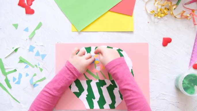 制作自制贺卡的孩子。小女孩用纸和粘土制成的鲜花篮子，橡皮泥作为母亲节或情人节的礼物。传统游戏概念。工