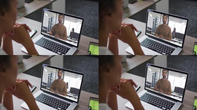 非裔美国妇女在办公室与男同事在笔记本电脑上进行视频通话