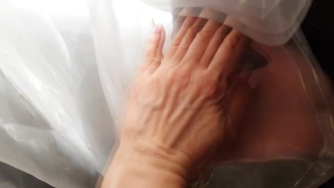 一个女人的手在她的房间里触摸和移动窗帘的织物的特写，查看窗帘上接缝的质量，4k视频