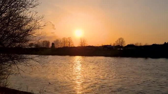 河上的日落。水的快速流动。太阳的明亮光线在水中反射。自然景观。地平线上树木的轮廓。