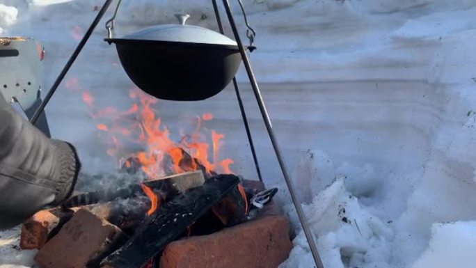 冬天，一个旅游锅挂在篝火上，冬天在大自然的火上做饭。4K