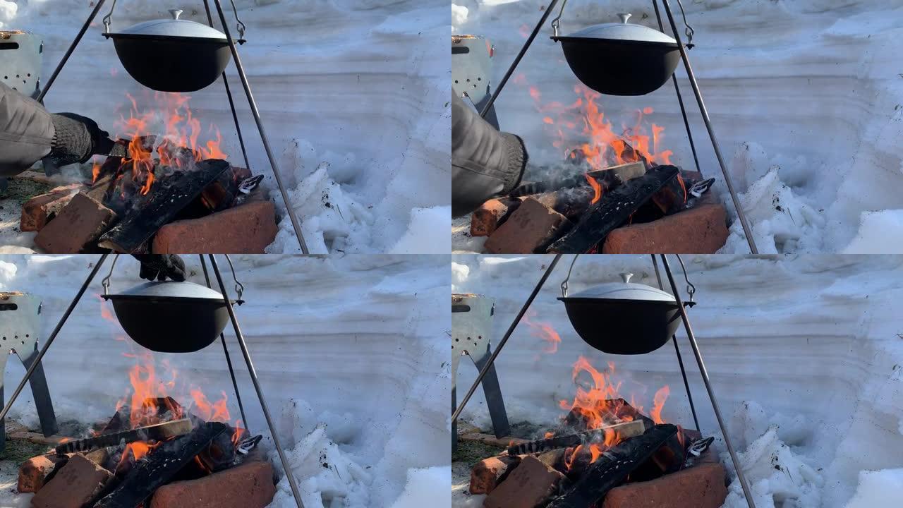 冬天，一个旅游锅挂在篝火上，冬天在大自然的火上做饭。4K