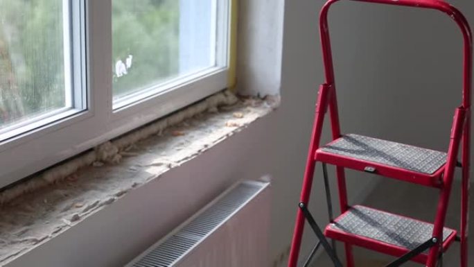 修理窗户的斜坡。在窗户的侧面涂一层灰泥的过程。