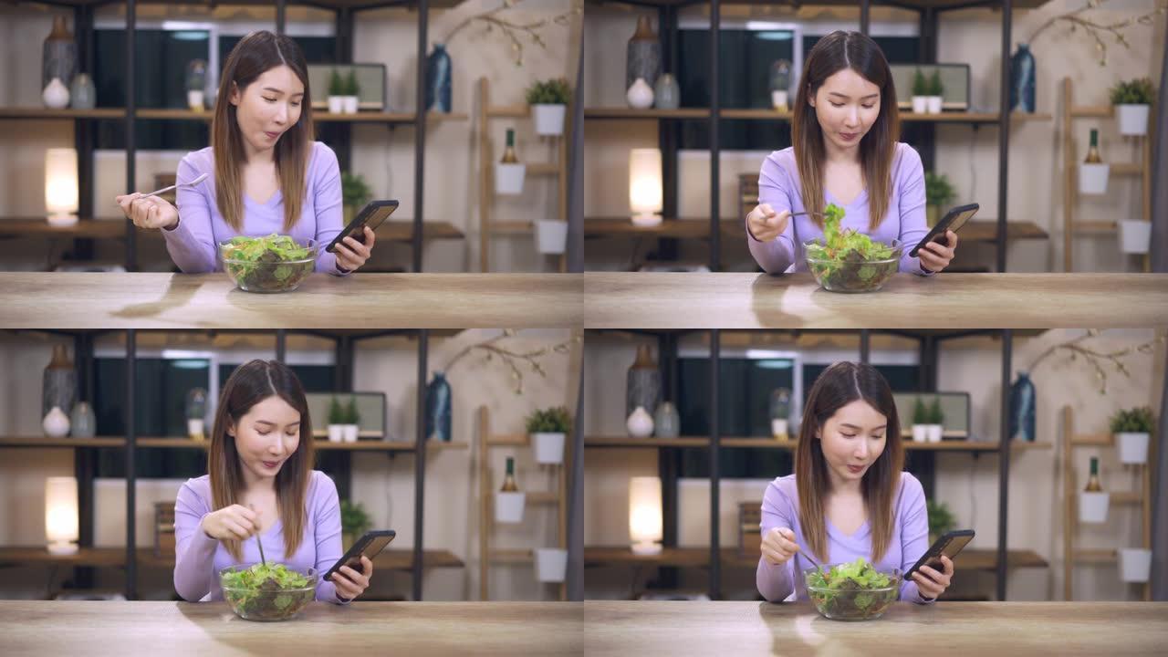 快乐的年轻女子用手机准备蔬菜沙拉