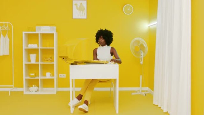 年轻的非洲妇女正在旧的黄色计算机上工作