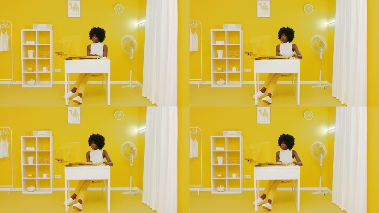 年轻的非洲妇女正在旧的黄色计算机上工作
