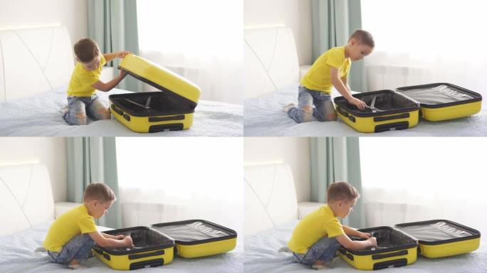 小男孩在房子的卧室里打开一个黄色的手提箱