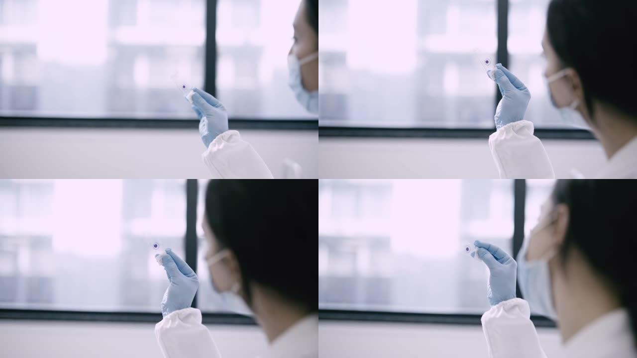 一位女科学家分析装在玻璃中的血液样本的4k视频片段