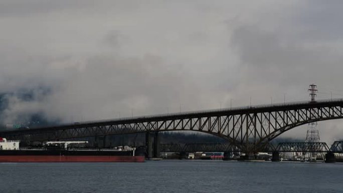 货船在阴天驶向温哥华的大桥