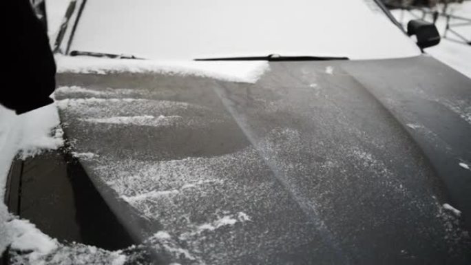 汽车的积雪覆盖的引擎盖被刷了。