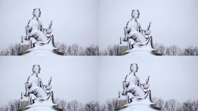冬天在法国巴黎的埃菲尔铁塔附近被雪覆盖的女人的雕像，在下雪天从下面看到