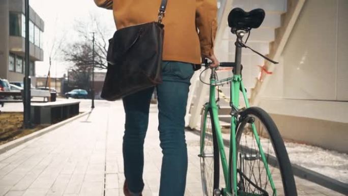 一个面目全非的时尚男人骑着自行车走路
