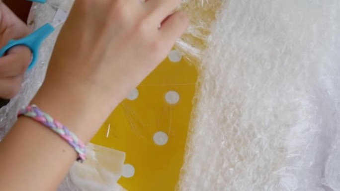 孩子的手打开彩色碗碟的包装，这是从网上购物购买在家，生活方式的概念。