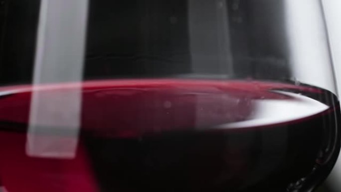 滴落缓慢的玻璃。葡萄酒掉落成红酒的特写镜头