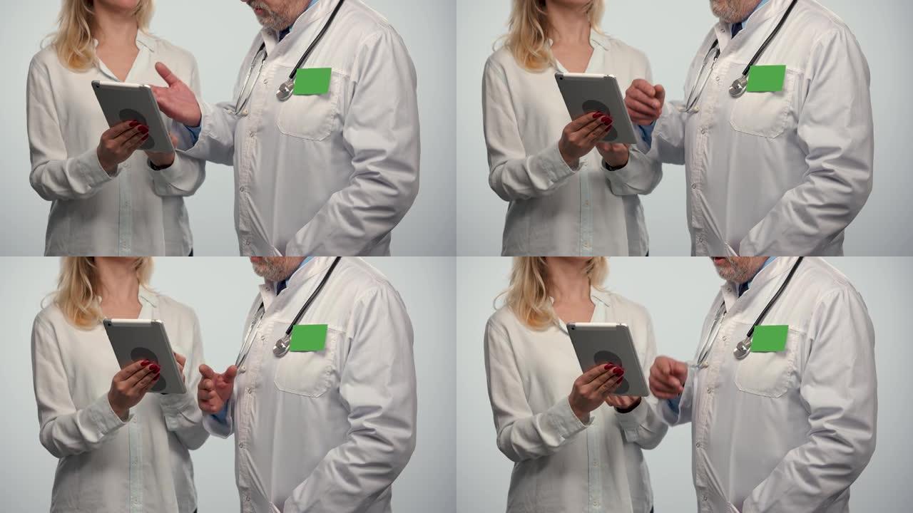 在医院的女性患者咨询期间，家庭医生会在平板电脑上交谈并显示信息。男士医生穿着白色医疗礼服，徽章绿色屏
