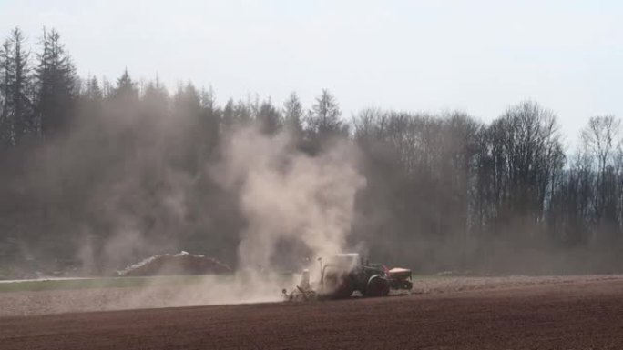 由于干燥的田野，拖拉机在田野上流失了灰尘