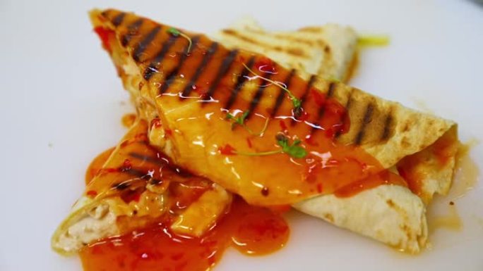 白色桌子上的沙瓦玛或烤肉串倒有浓汤。皮塔饼卷是用玉米饼，牛肉，番茄，洋葱和生菜制成的。