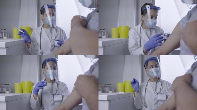女医生给老人接种疫苗，同时戴着防电晕病毒的面罩