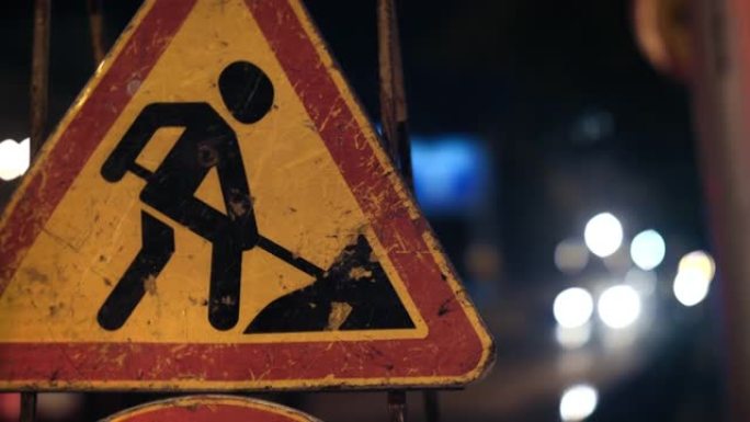 警告司机道路工程的路标特写镜头。垃圾道路交通标志。信号灯在背景中闪烁