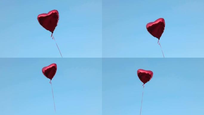一个充满氦气的心形红色箔气球在无云天空的背景下飞行。爱情概念，情人节，关系。全高清视频素材
