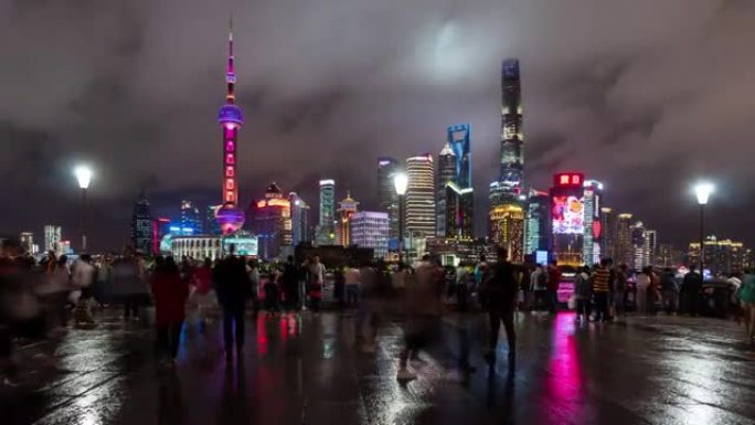 4k时间流逝: 人们在中国上海外滩观光点步行和拍摄陆家嘴摩天大楼灯光秀的照片。