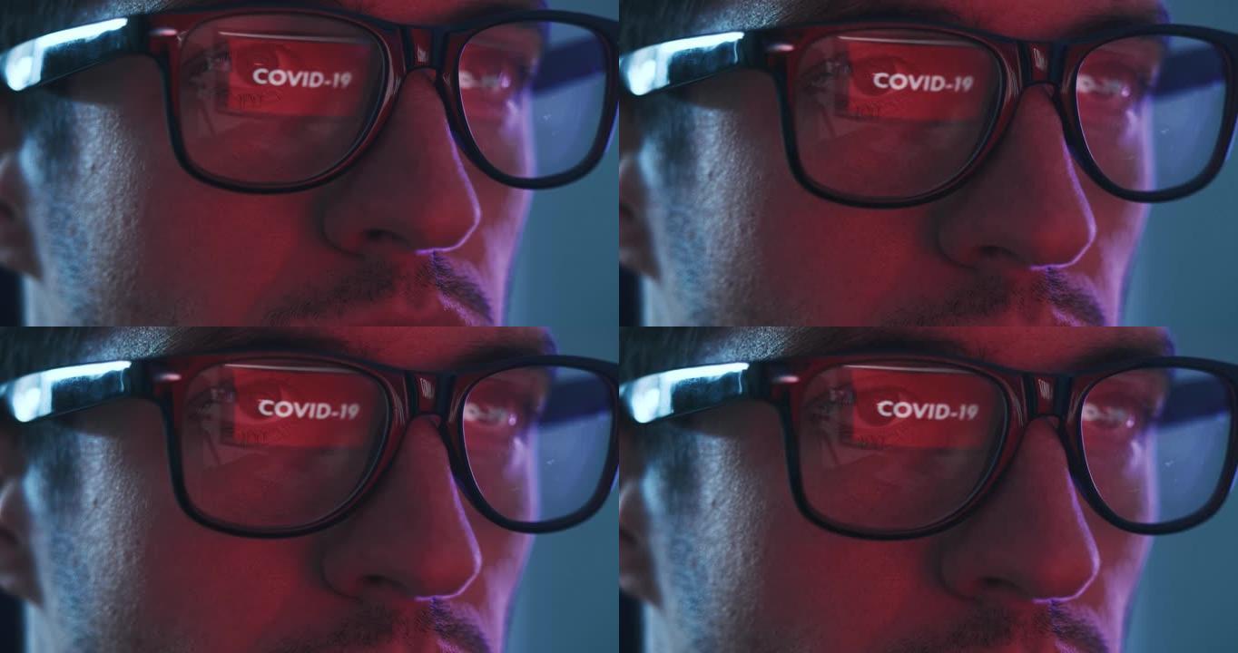 眼镜中的反射，冠状病毒警告，使用笔记本电脑的人，晚上阅读有关covid 19的新闻