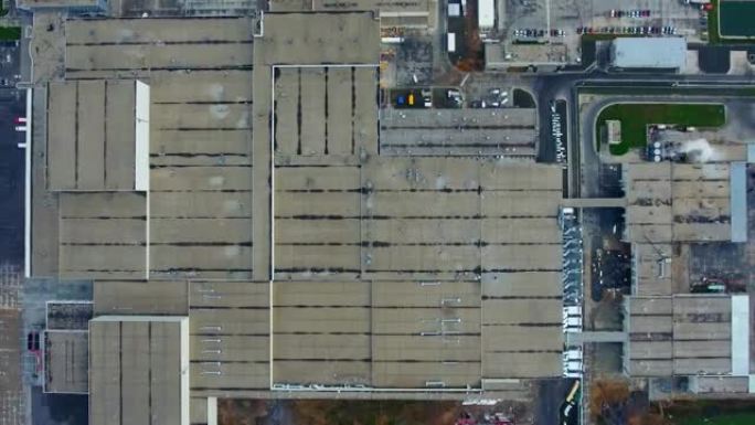 工业厂房。工厂的巨大领土。工业建筑的屋顶。制造商附近的停车场。相机升起。俯视图。
